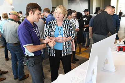 Pantex summer intern Bryan explains his summer project to Chief Operating Officer Michelle Reichert during the Intern Expo