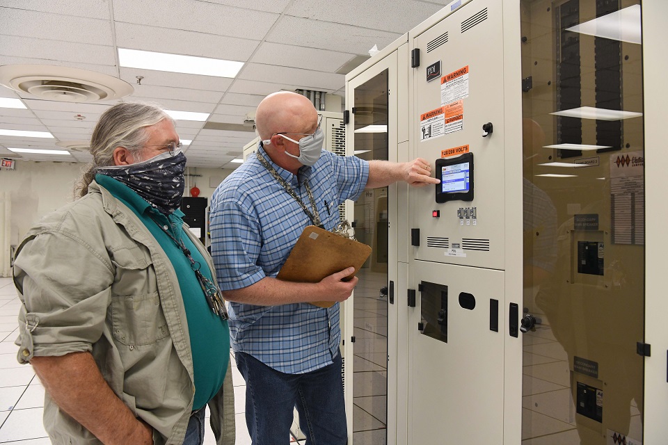 IT Systems administrators John Neusch (right) and Les Spaulding troubleshoot a new power distribution system in Pantex’s current data center
