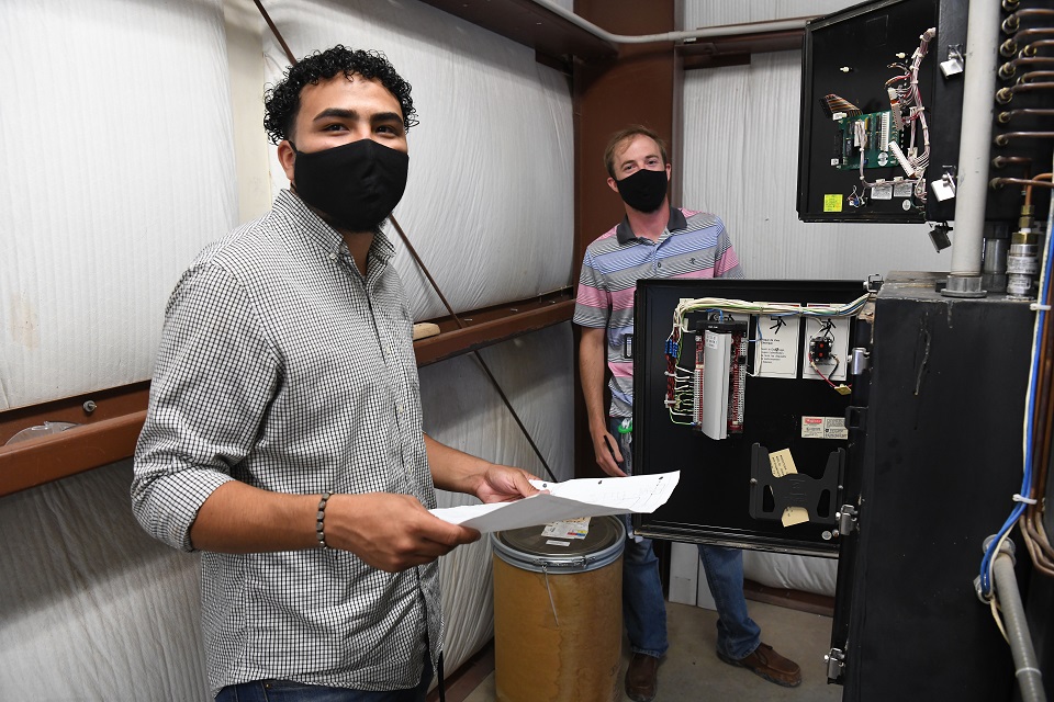Pantex summer intern Hector Rivero-Figueroa, left, works on a compressor air filter design with coworker Clint Hanes. Social distancing and face coverings were the norm during internship 2020.