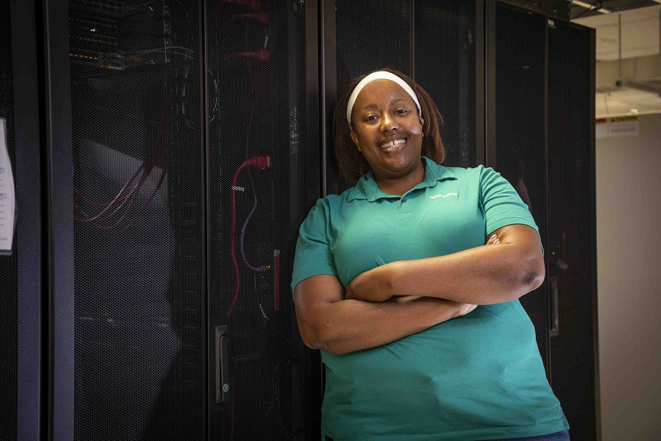 Kami Bush, who supports CNS’s VMware virtual infrastructure, stands in front of a Y-12 server rack in Building 9117.