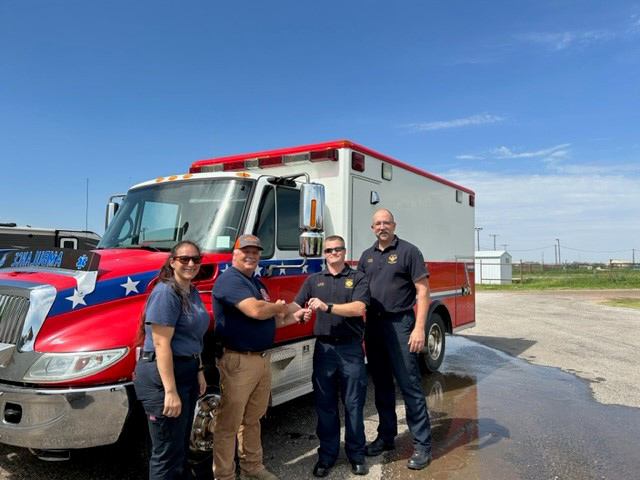 Members of the Pantex Fire Department hand over the keys to the loaned ambulance to the City of Perryton